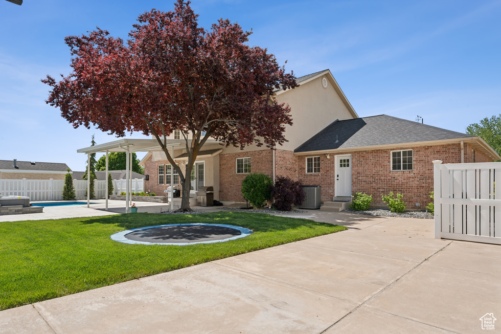 Rear view of house featuring cooling unit, brick siding, a patio, roof with shingles, and entry steps