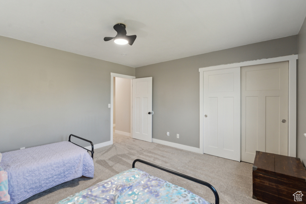 Bedroom with carpet flooring, baseboards, a closet, and ceiling fan