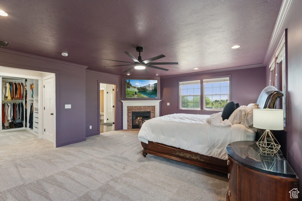 Bedroom with carpet flooring, ornamental molding, recessed lighting, a brick fireplace, and a ceiling fan