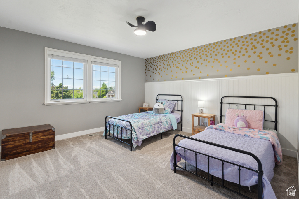 Bedroom featuring a wainscoted wall, baseboards, carpet, and wallpapered walls