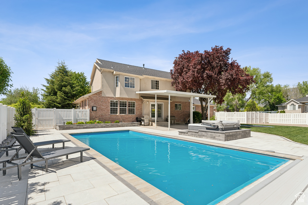 View of swimming pool with a patio area, a fenced backyard, and an outdoor hangout area