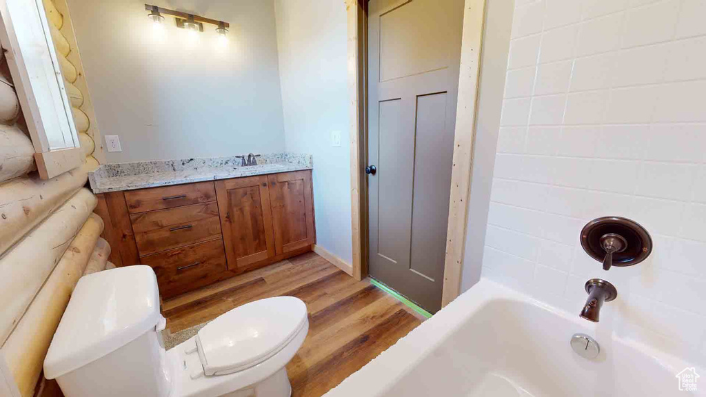 Full bathroom with toilet, wood finished floors, and vanity