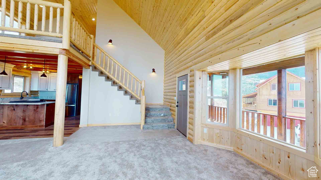 Unfurnished living room with stairway, carpet, high vaulted ceiling, and wood ceiling