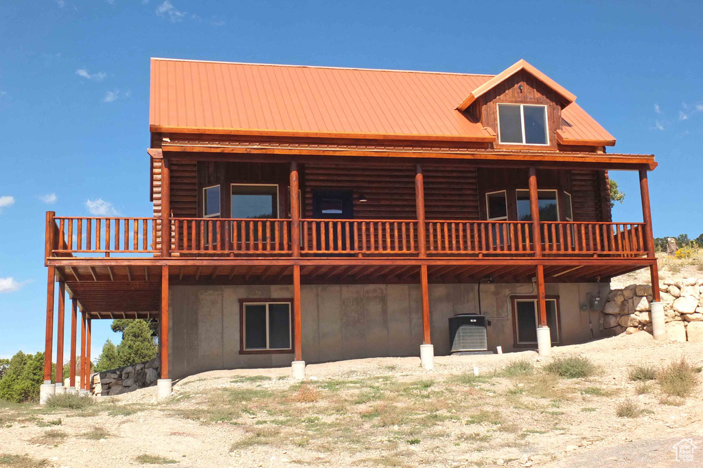 Rear view of property with a wooden deck and metal roof