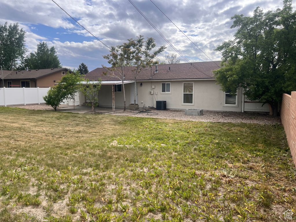 Rear view of house featuring central AC unit, a patio area, and stucco siding
