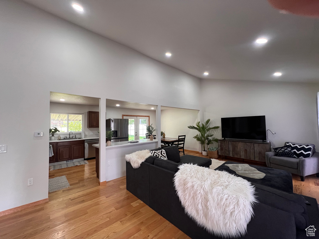 Living area with recessed lighting, light wood-style floors, and french doors
