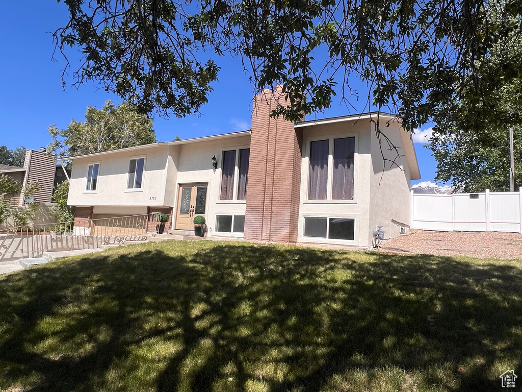 Rear view of house featuring stucco siding, a chimney, and french doors