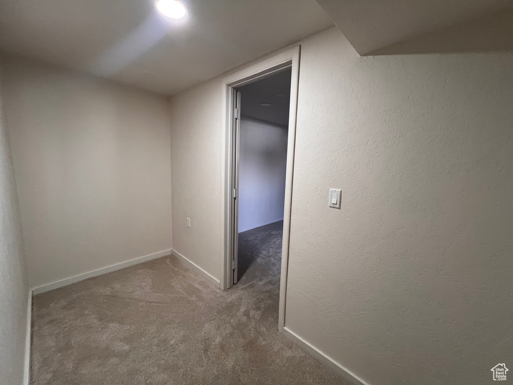Hallway featuring carpet floors and baseboards