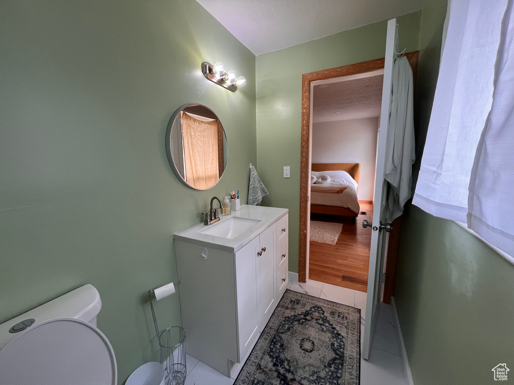 Bathroom with connected bathroom, vanity, toilet, and baseboards