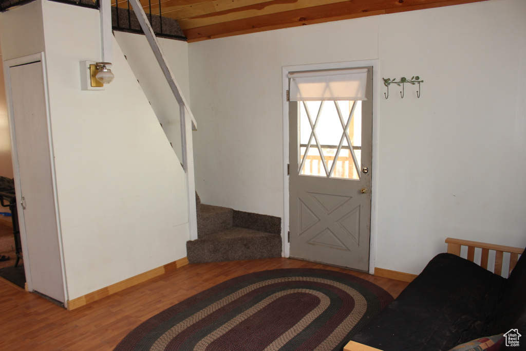 Foyer entrance with stairs, wood finished floors, and baseboards