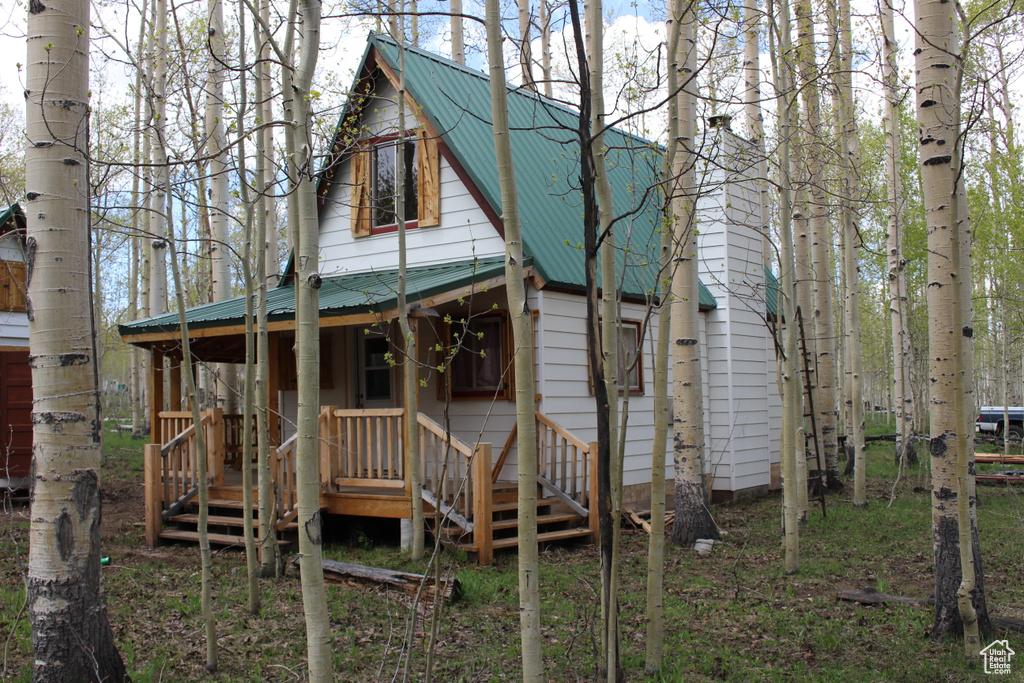 Rear view of property featuring metal roof and covered porch