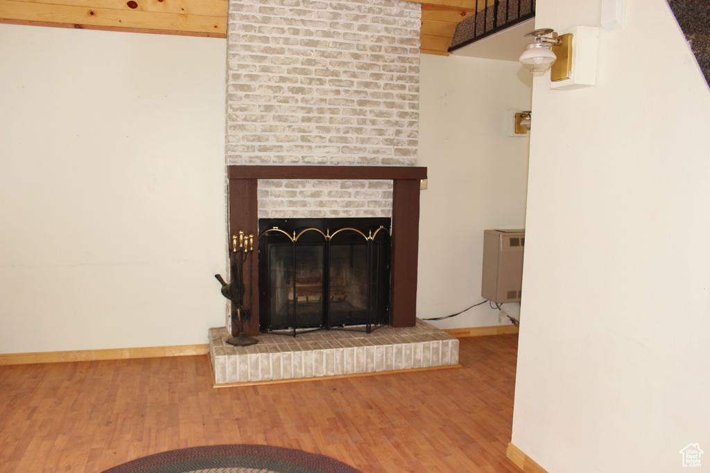 Detailed view of wood finished floors, baseboards, and a brick fireplace