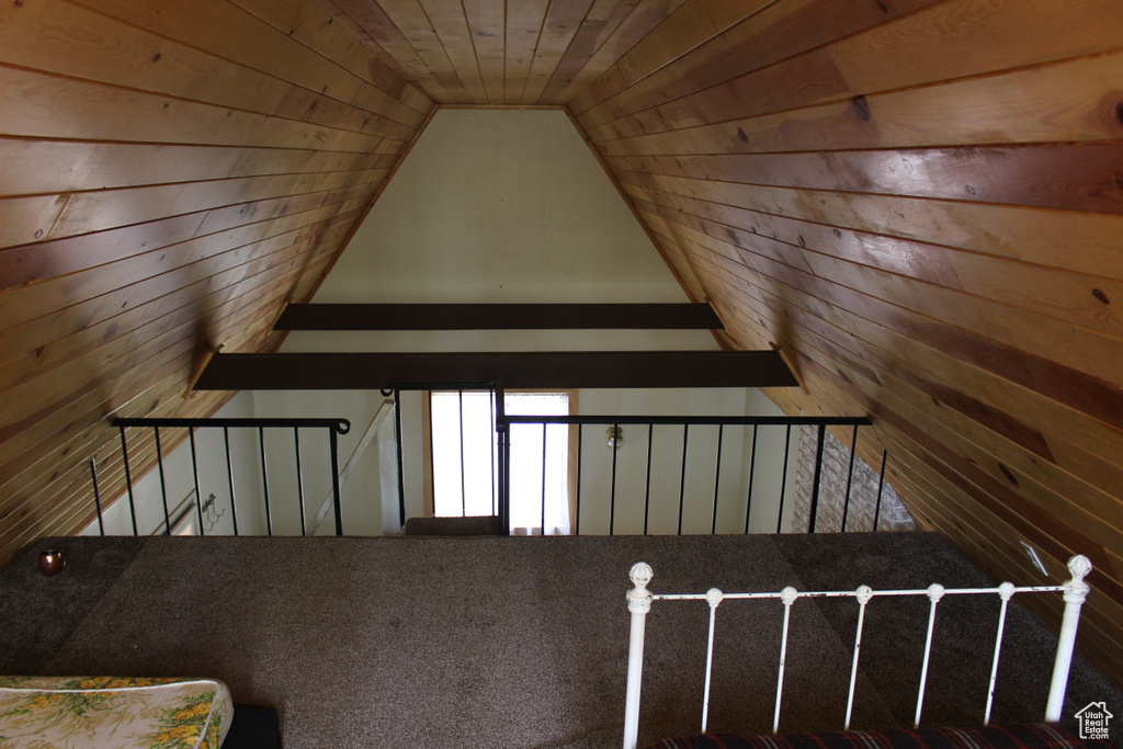 Stairs featuring wooden walls, vaulted ceiling, and wooden ceiling