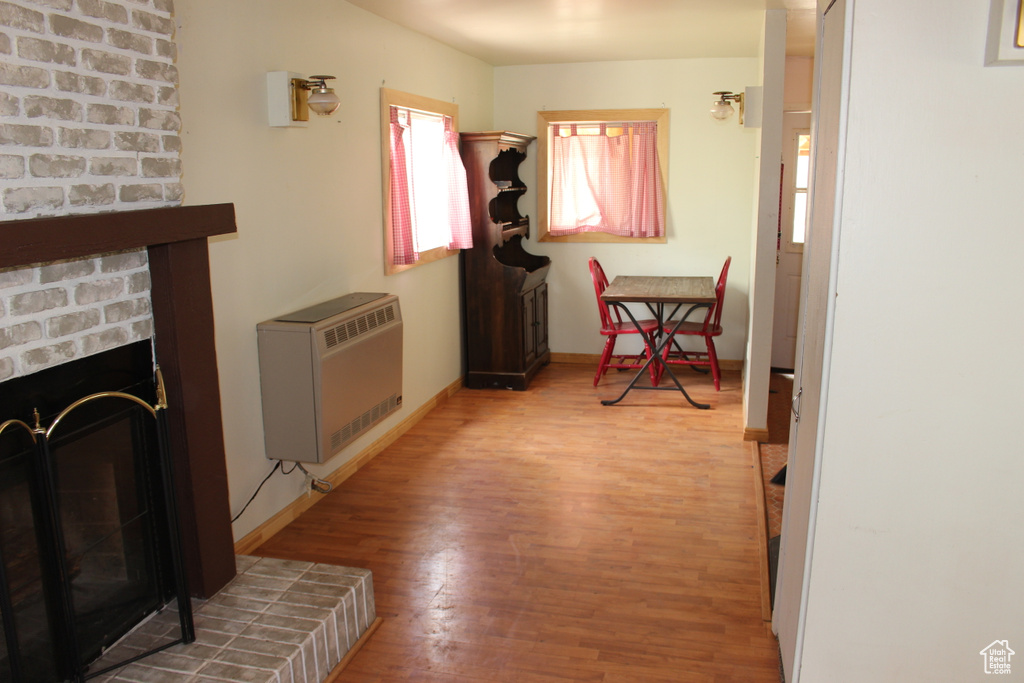 Hall featuring heating unit, wood finished floors, and baseboards