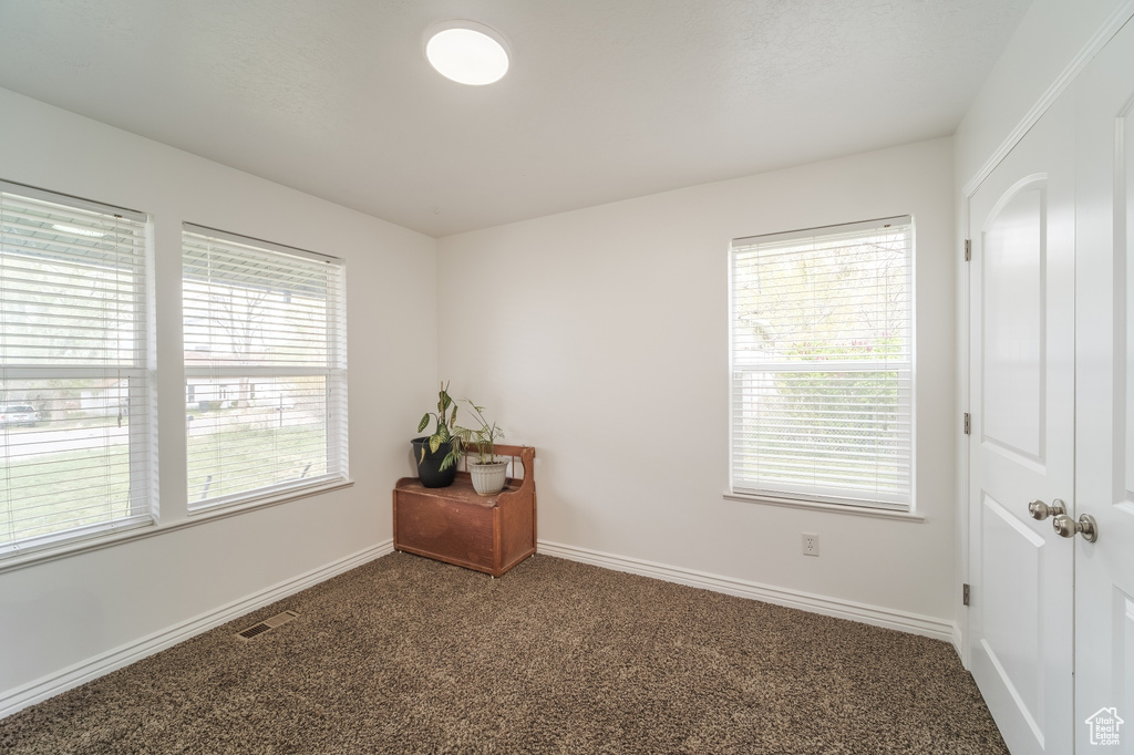 Carpeted empty room featuring baseboards
