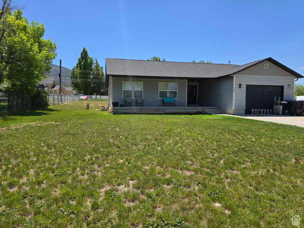 Single story home with covered porch, an attached garage, and driveway