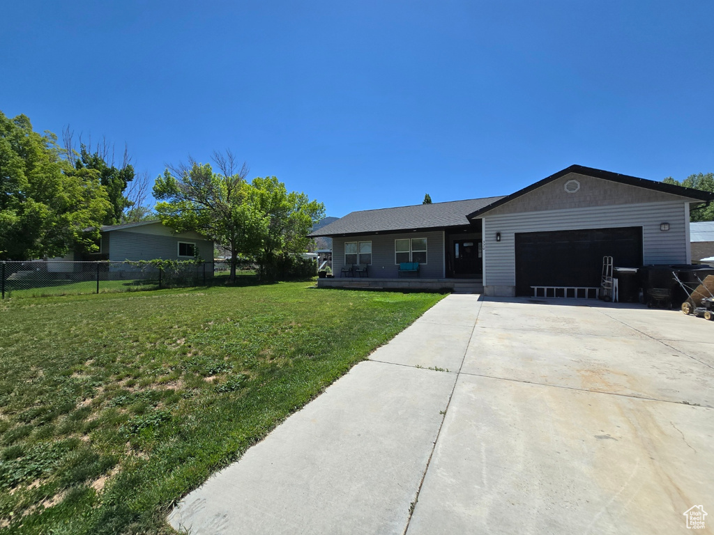 Single story home with a garage, driveway, and covered porch
