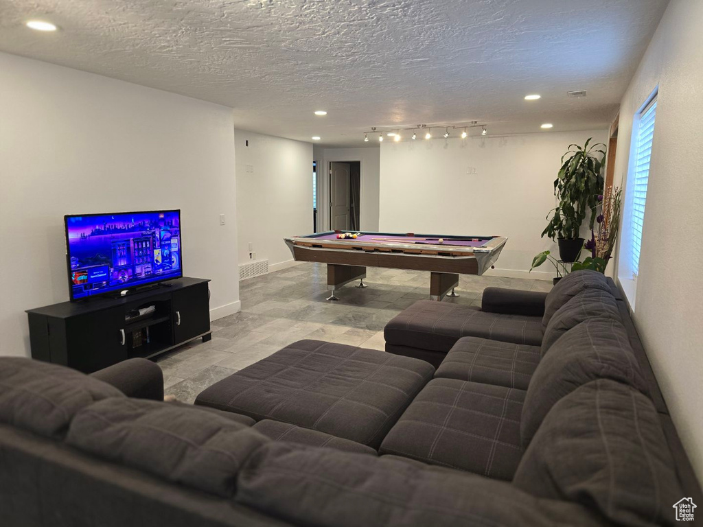 Living room with billiards table, recessed lighting, a textured ceiling, and baseboards