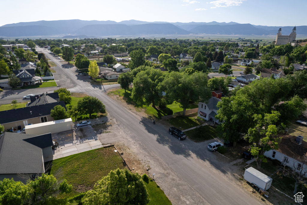 Aerial view of property and surrounding area featuring a mountainous background and nearby suburban area