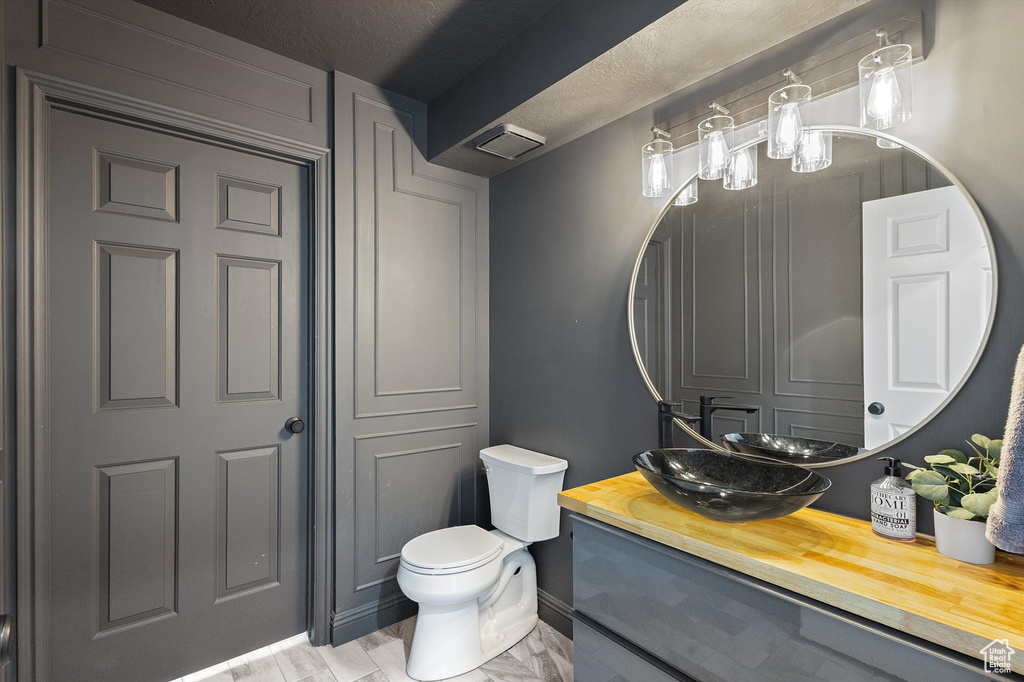 Bathroom with baseboards, toilet, and vanity