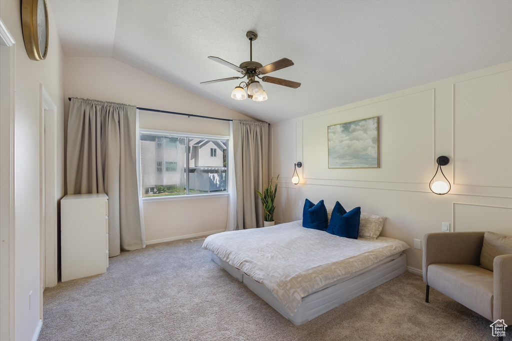 Bedroom with lofted ceiling, carpet flooring, ceiling fan, and baseboards