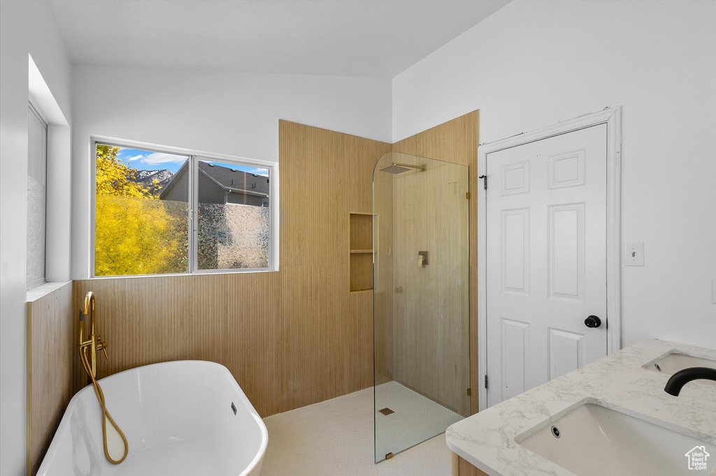 Full bath featuring a soaking tub, walk in shower, and double vanity
