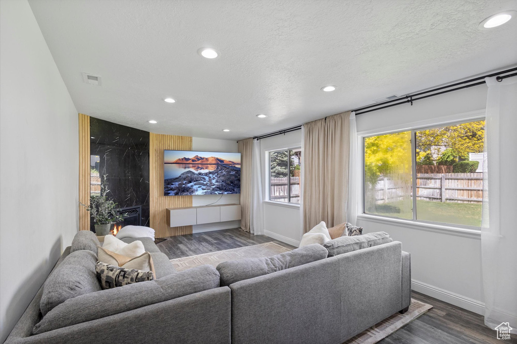 Living area featuring recessed lighting, wood finished floors, baseboards, and a textured ceiling