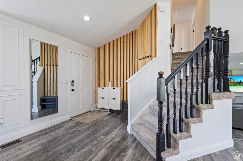 Stairway with wood finished floors, baseboards, and recessed lighting