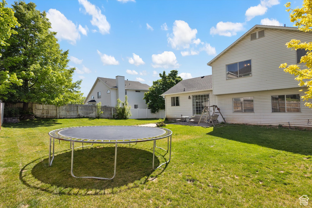 Rear view of property featuring a trampoline