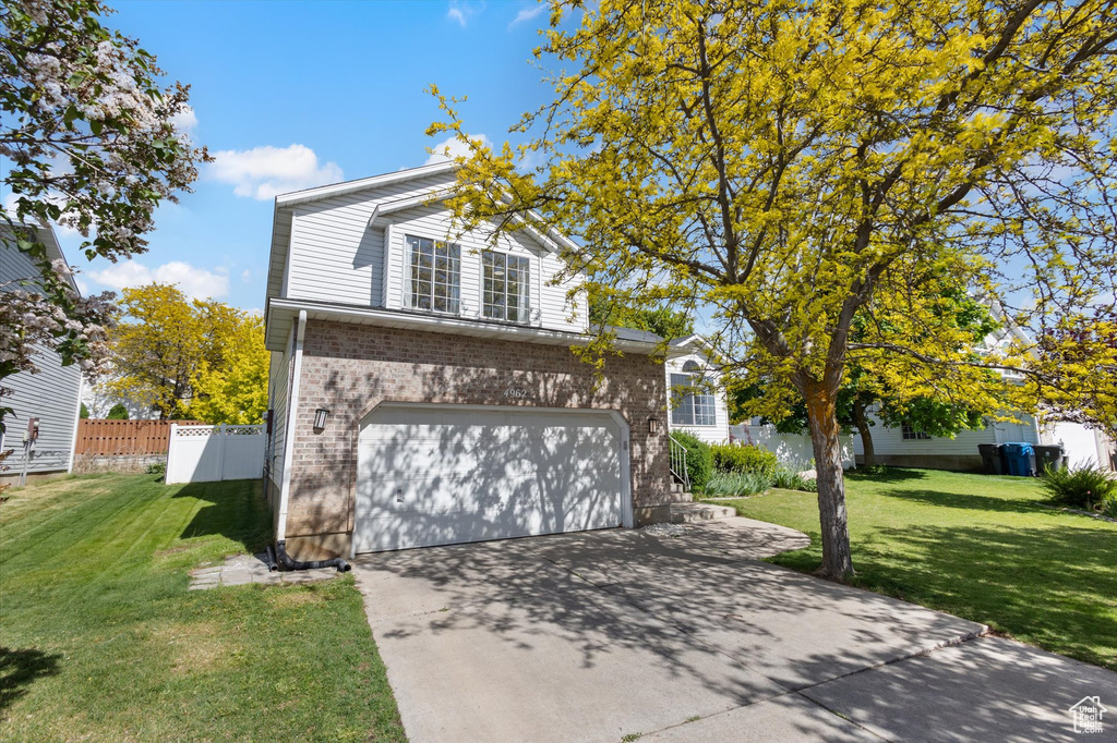 Traditional-style home with a garage, brick siding, and concrete driveway