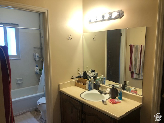 Full bath featuring toilet, vanity, and shower / tub combination