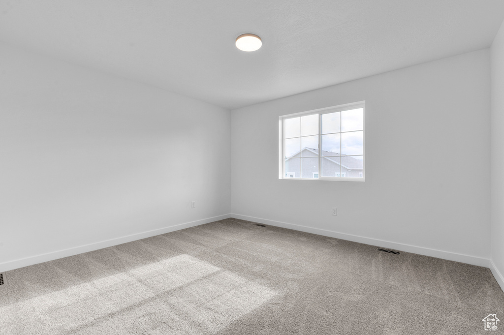 Empty room featuring carpet flooring and baseboards
