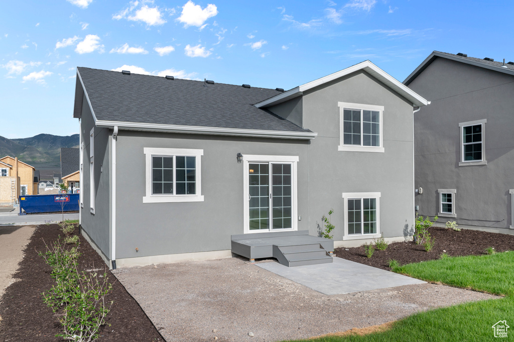 Rear view of property with a patio, a mountain view, stucco siding, and roof with shingles