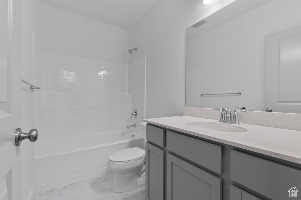 Full bath with marble finish flooring, toilet, shower / tub combination, and vanity