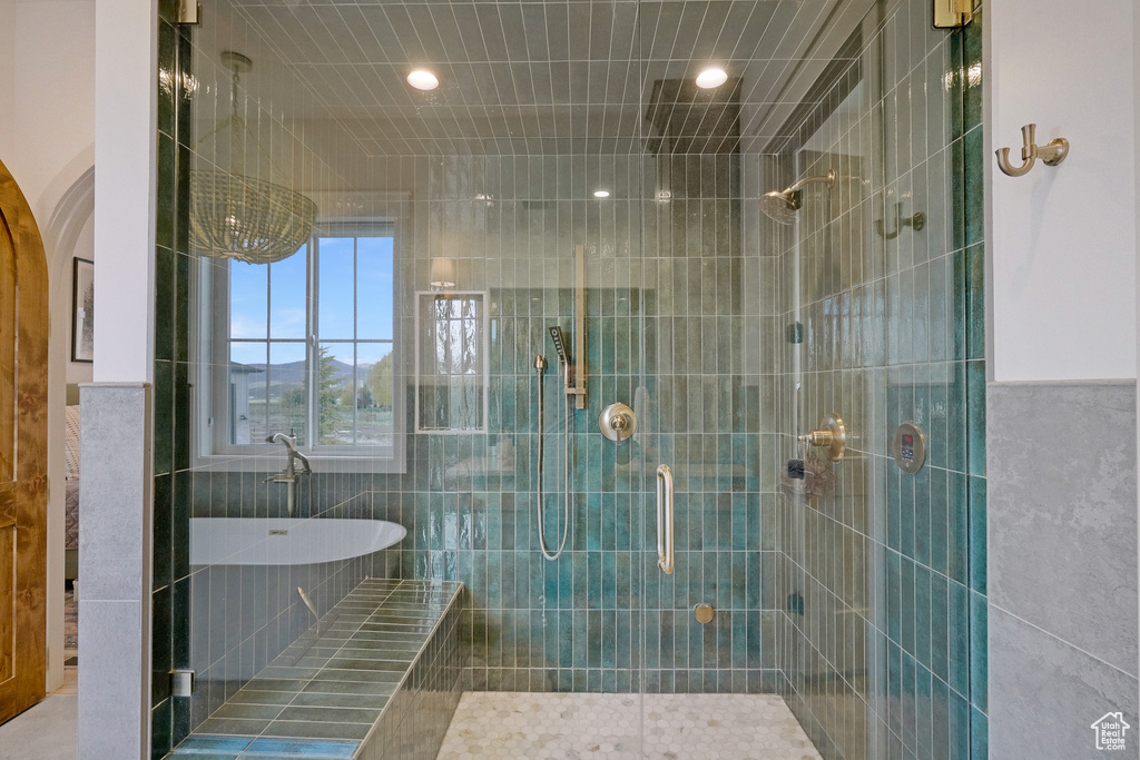 Bathroom with a shower stall, recessed lighting, tile walls, and a freestanding tub
