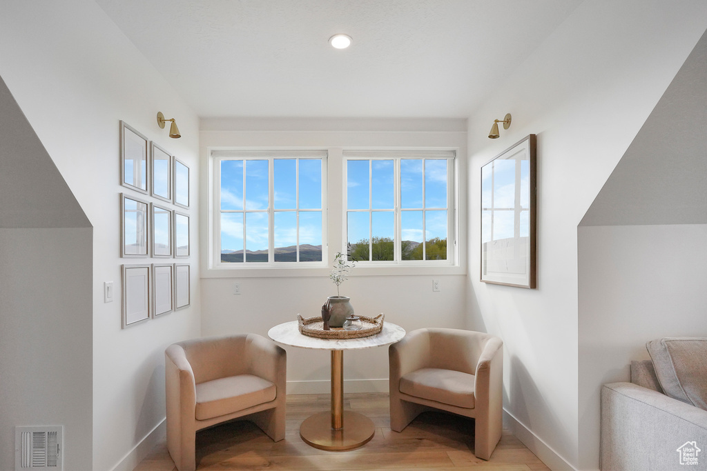Living area featuring baseboards, light wood-style floors, and recessed lighting