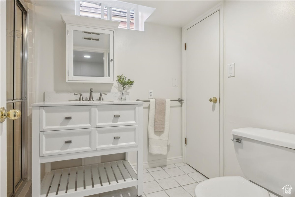 Bathroom featuring toilet, tile patterned flooring, a shower stall, and vanity