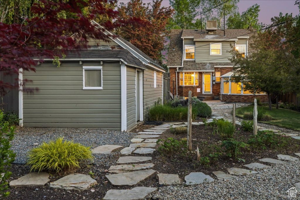 Back of house featuring an outbuilding and brick siding
