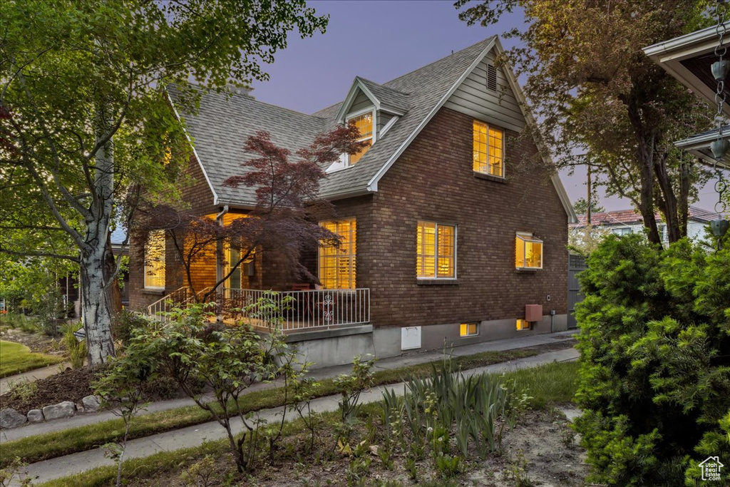 View of front of house with brick siding and a shingled roof