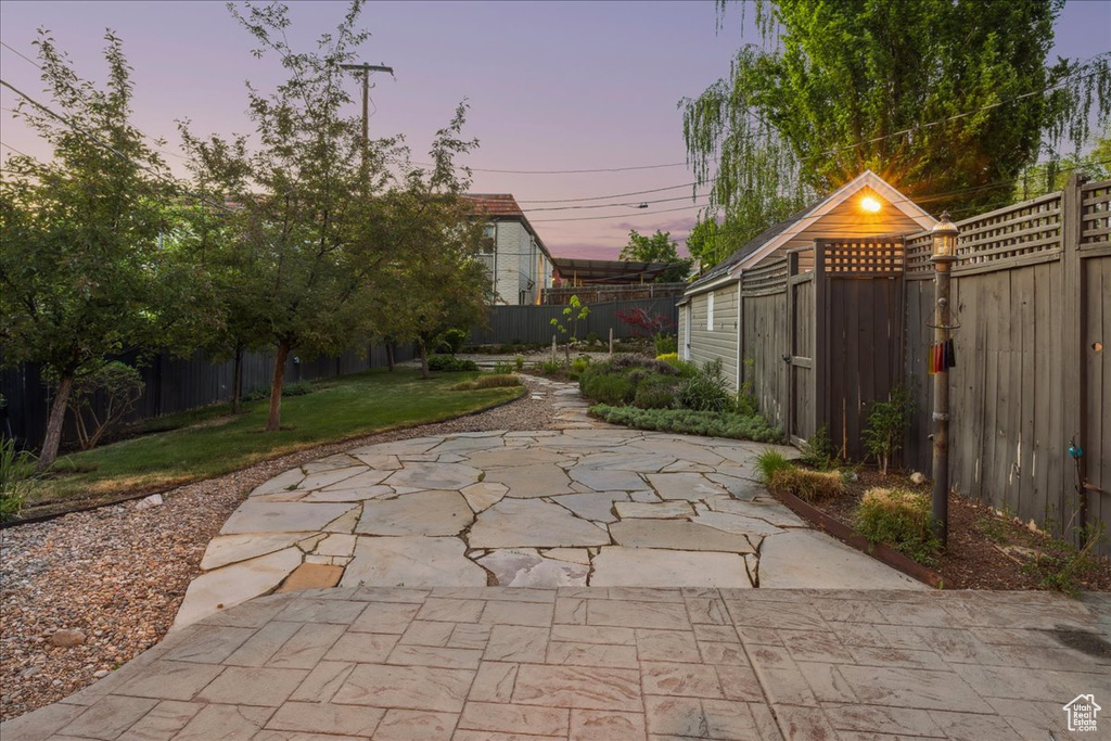 Yard at dusk featuring a patio