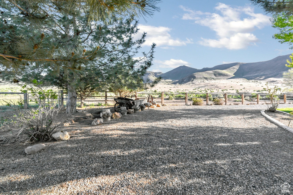 View of yard featuring a mountain view, fence, and a view of rural / pastoral area