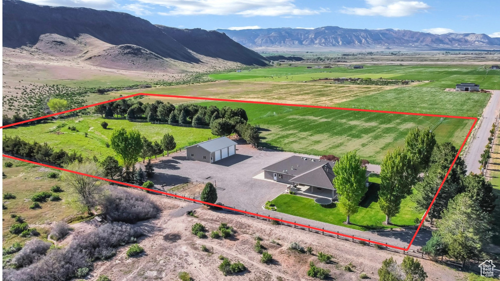 Aerial view of sparsely populated area with property parcel outlined and a mountain backdrop
