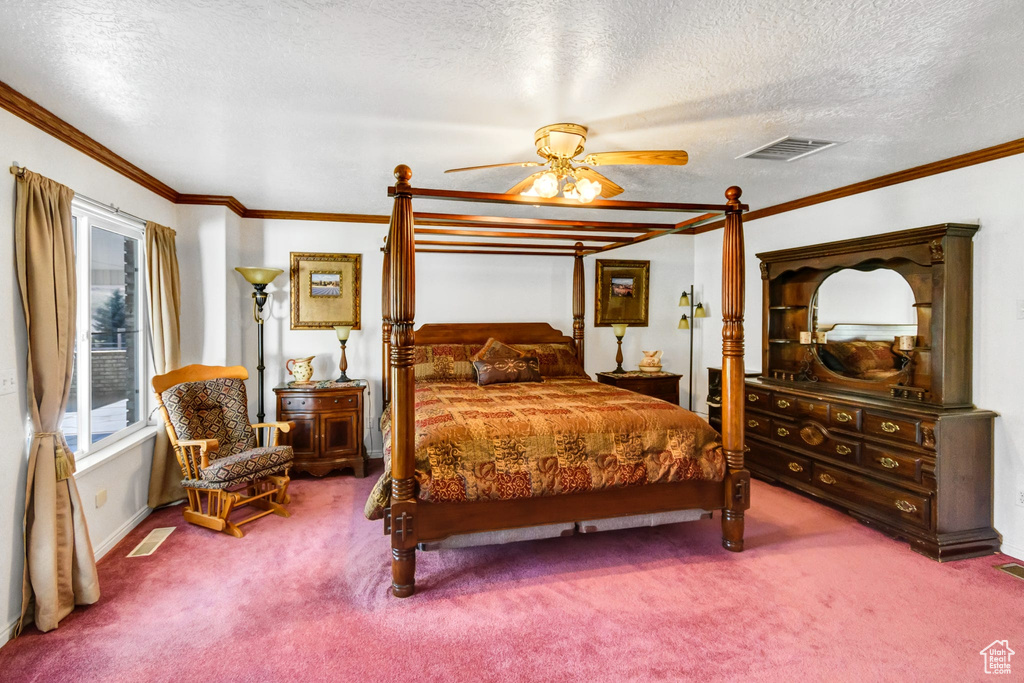 Bedroom with carpet floors, ornamental molding, a textured ceiling, baseboards, and ceiling fan