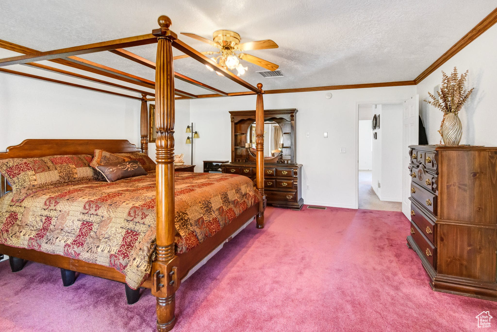 Carpeted bedroom featuring crown molding and a textured ceiling