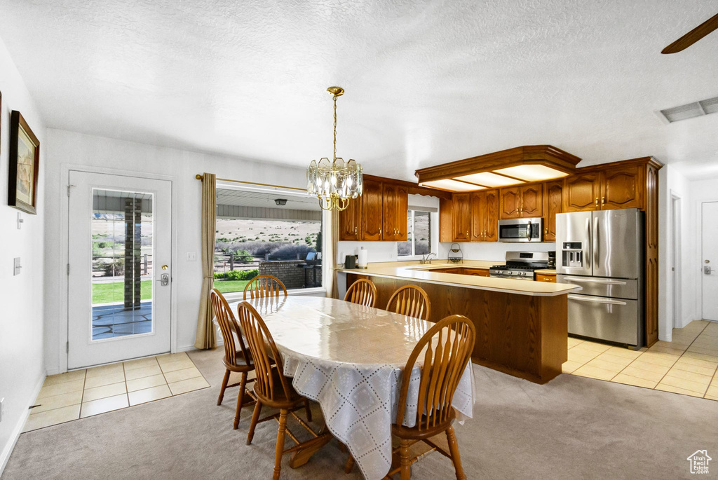 Dining space with light carpet, a chandelier, light tile patterned floors, a textured ceiling, and ceiling fan