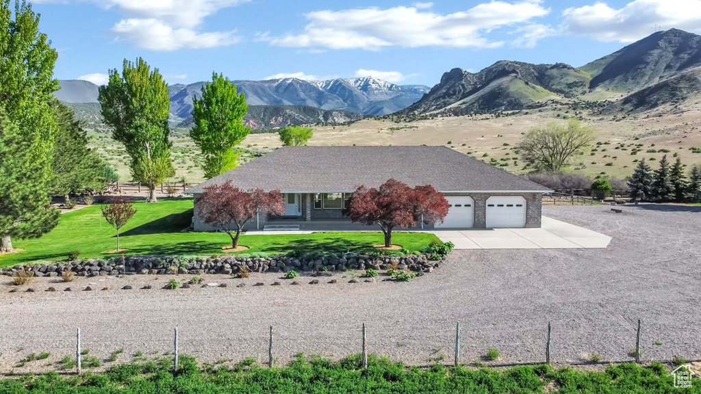View of front facade with an attached garage, concrete driveway, and a mountain view
