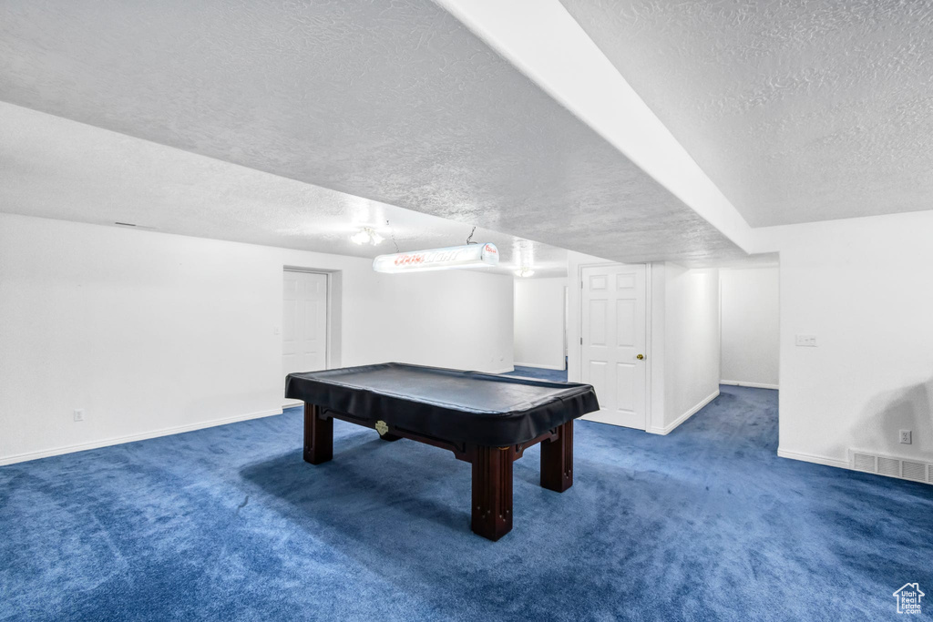 Recreation room featuring a textured ceiling, carpet flooring, baseboards, and billiards