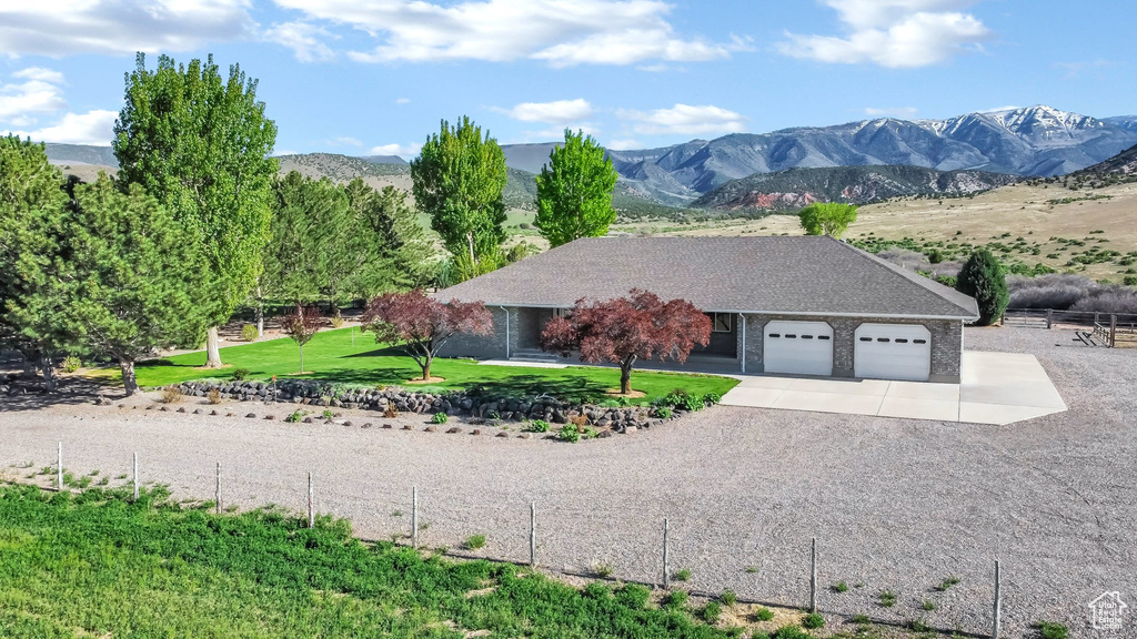 View of front of property with an attached garage, driveway, and a mountain view
