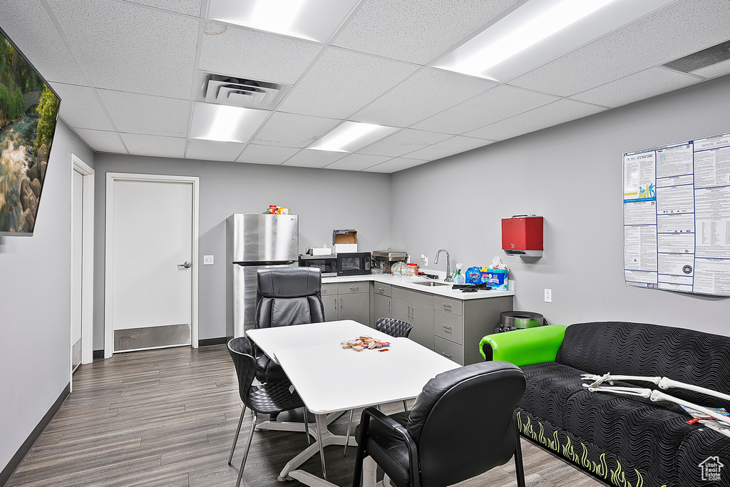 Office space with a sink, dark wood-style floors, a drop ceiling, and baseboards