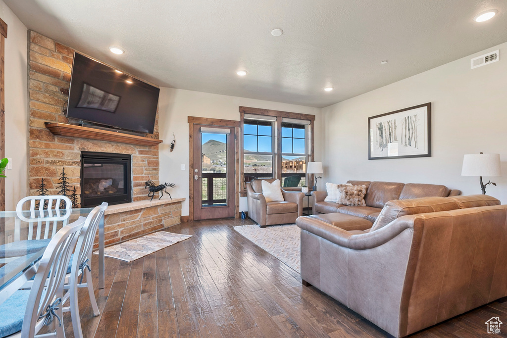 Living area featuring dark wood-type flooring, a fireplace, and recessed lighting